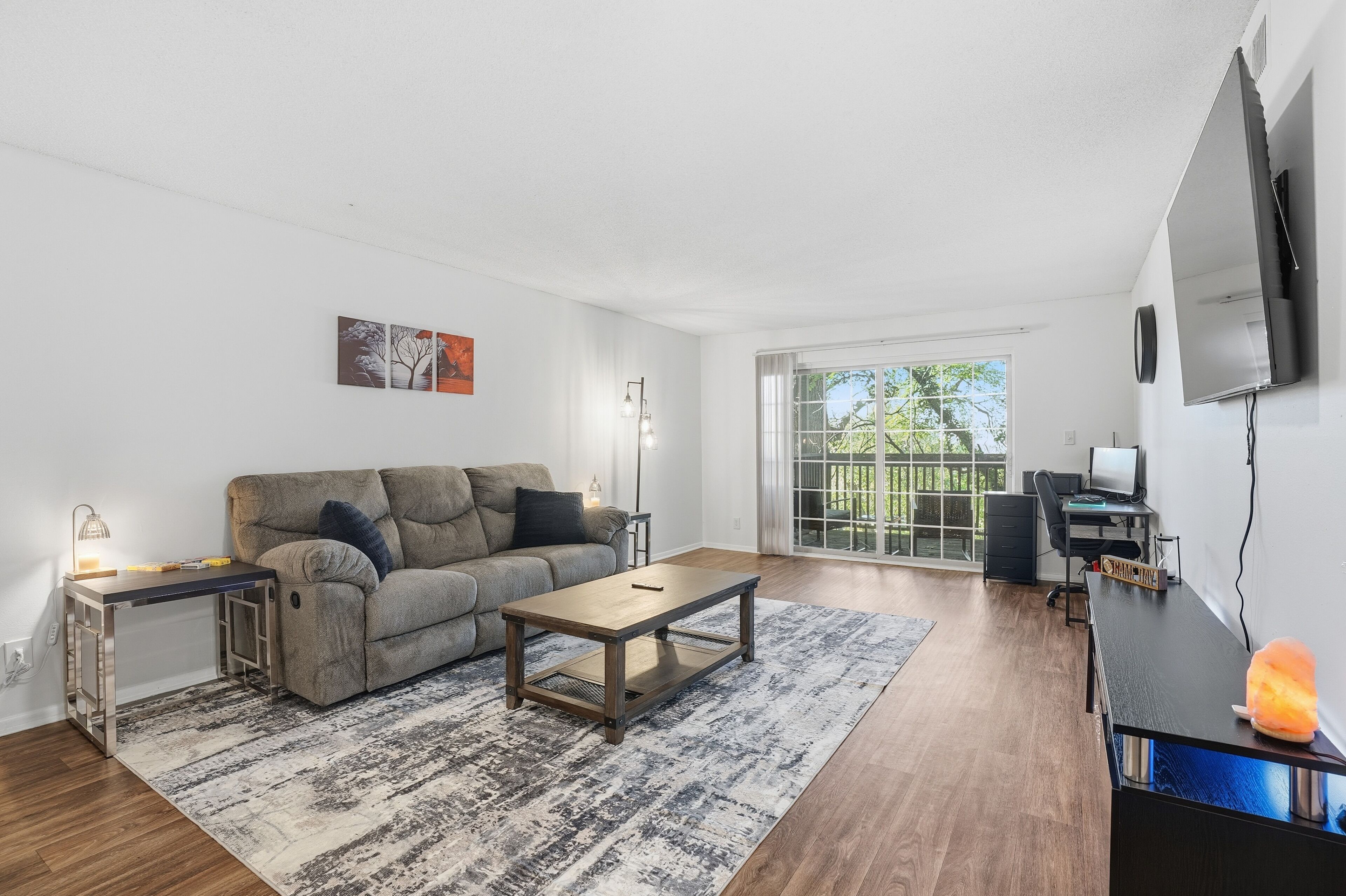 A modern living room with a sofa, coffee table, and a flat-screen TV.