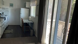 A compact kitchen with a dining table, a refrigerator, and a window with blinds. - Contemporary, marine 2bd/1ba Apartment in Kent (kent)