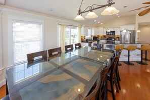 A modern kitchen with stainless steel appliances, a glass dining table, and wooden flooring. - Absolut Paradise - 8 bedrooms private pool, hot tub (Virginia Beach)