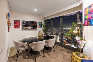 Ein Essbereich mit Blick auf die Stadt, ein Tisch mit Stühlen und Dekorationselementen.