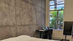 Een slaapkamer met een groot bed, een bureau met een computer en een televisie.