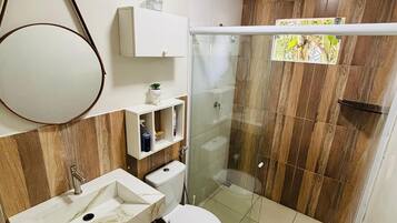 Chuveiro, secador de cabelo, toalhas de banho, papel higiênico