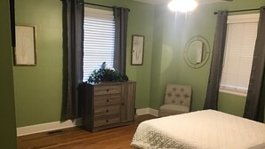 A bedroom with a bed, dresser, chair, and a window with curtains. - Enjoyable house with AC in Augusta - 2 bedrooms, perfect getaway. (Augusta)