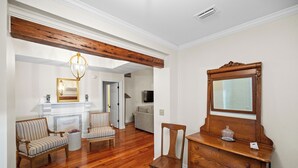 Una sala de estar con chimenea, muebles de madera, un espejo y un televisor al fondo.