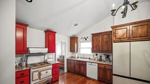 Una cocina con armarios de madera, una estufa blanca y un refrigerador.