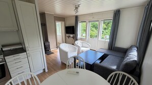 Una habitación con kitchenette, una mesa de comedor, un sofá y un televisor.