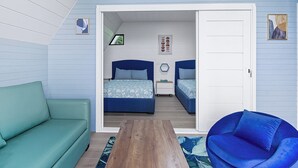 Een slaapkamer met twee bedden, een groene bank, een blauwe stoel en een houten tafel.