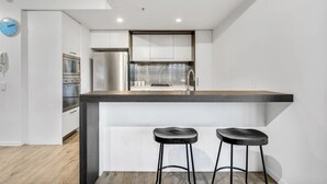 Een moderne keuken met een centraal eiland, roestvrijstalen apparatuur en een minimalistisch design.