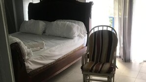 A bedroom with a bed, a chair, and curtains. - Enjoyable 2nd story, 3-bedroom house with AC in Coamo, PR (Coamo)