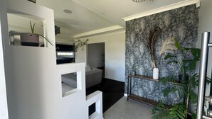 A modern interior with a loft-style bedroom, a kitchen, and a living area.