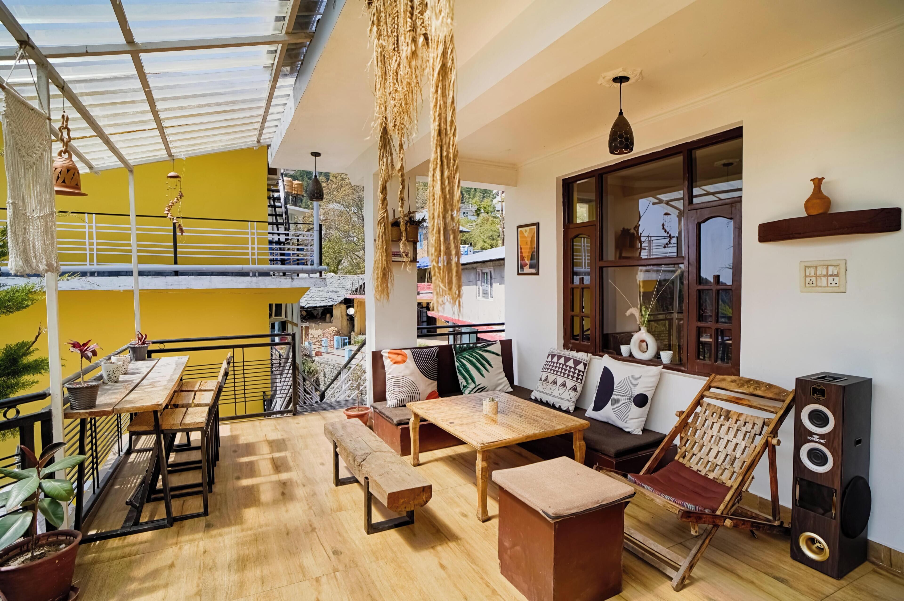 A spacious balcony with wooden furniture, a wooden bench, and a cushioned seating area.