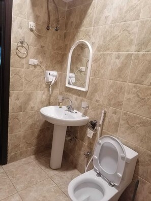 A bathroom with a sink, mirror, and toilet. - fakhamat almasif (Taif)