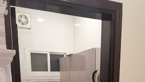 A compact kitchen with a gas stove, a sink, and a refrigerator. - fakhamat almasif (Taif)
