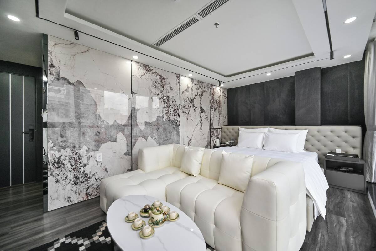 Une chambre moderne avec un grand lit, un canapé et une table basse.