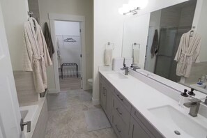 Douche, baignoire à remous, séchoir à cheveux, serviettes fournies
