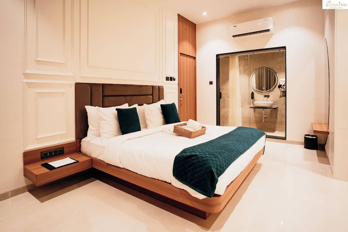 A modern bedroom with a large bed, a wooden headboard, a bedside table, and a built-in wardrobe.