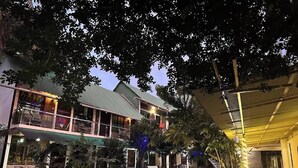 A two-story building with a covered outdoor area, a tiled courtyard, and surrounding greenery. - Sampan Resort (Cox's Bazar)