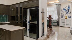 Una cucina moderna con mobili scuri, un'isola centrale e un'area pranzo con una scala.