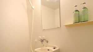 A bathroom with a bathtub, sink, and two shampoo bottles on a shelf. - Cozy Stay in Nakano Honcho - 7min to Shin-Nakano, 2 Stops to Shinjuku(33) (中野区本町)