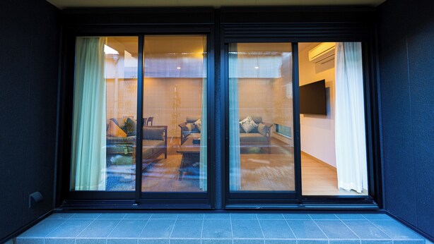 Une entrée moderne, avec des portes en verre et un sol carrelé.