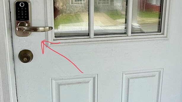 A white door with a keypad lock and a window above it.
