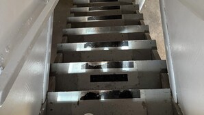 A staircase with metal railings and a concrete floor.
