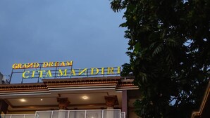 The exterior of the Grand Dream Cita Mazdiri hotel with a prominent sign and a balcony.