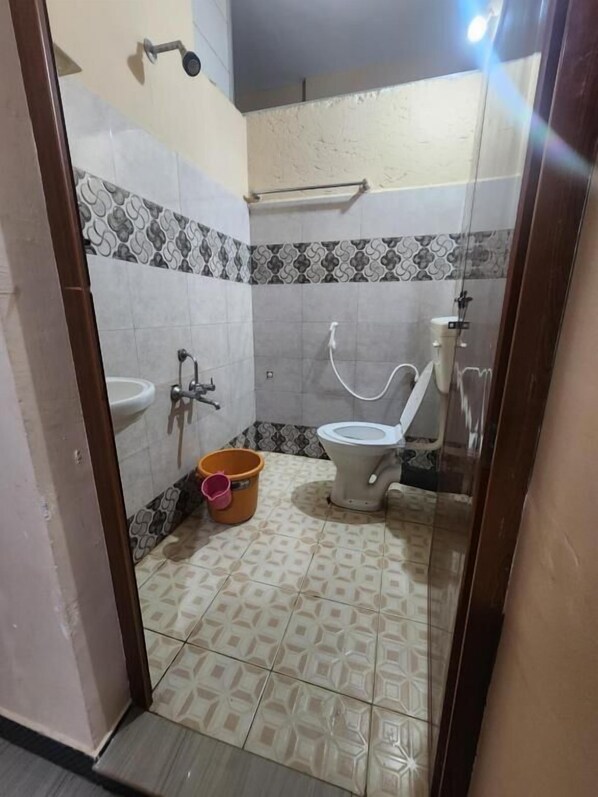 Un baño pequeño con inodoro, lavabo y ducha.