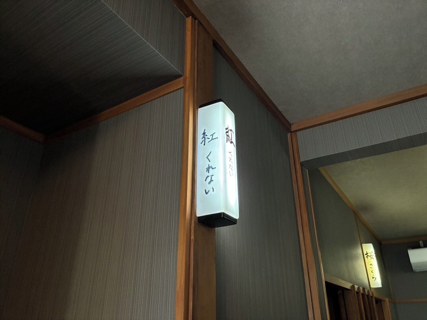 Ein traditionelles japanisches Interieur mit Holzbalken und einem Schild mit japanischen Schriftzeichen.
