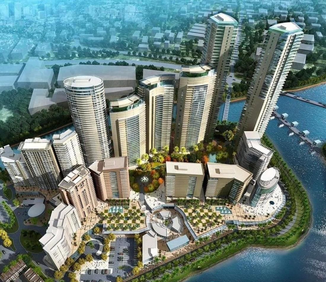 A high-rise residential complex with multiple buildings, a central landscaped area, and a waterfront.