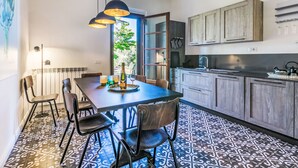 Una cucina moderna con mobili in legno scuro, una grande isola centrale e luci a sospensione.
