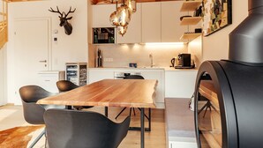 Una cocina moderna con armarios de madera, una isla central y una parrilla negra.