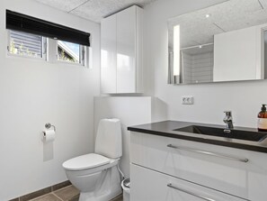 Une salle de bain moderne avec des toilettes, un lavabo et un miroir.