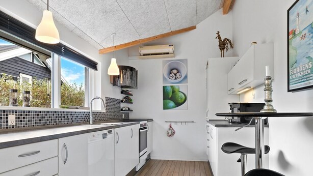 A modern kitchen with white cabinets, a wooden floor, and pendant lighting. - "Lanica" - 150m from the sea by Interhome (Mesinge)
