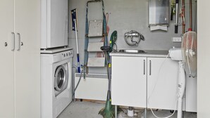 A compact laundry room with a washing machine, drying rack, and a sink. - "Lanica" - 150m from the sea by Interhome (Mesinge)