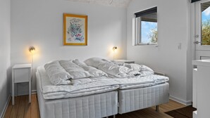 A bedroom with a double bed, two bedside tables, a window, and a ceiling light fixture. - "Lanica" - 150m from the sea by Interhome (Mesinge)