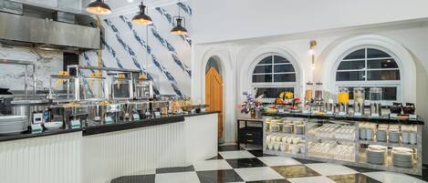 A buffet area with a checkered floor, a marble wall with blue patterns, and a variety of food and drink stations.