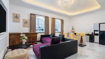 Una sala de estar moderna con sofá, reposapiés y mesa de comedor.