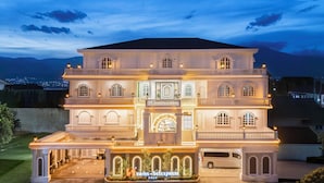 A large, multi-story building with a central entrance, balconies, and a driveway. - Swiss-Belexpress Palu (Palu)