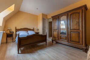 Une chambre à coucher avec un lit en bois, une armoire et un puits de lumière.