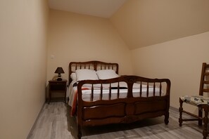 Une chambre à coucher avec un lit en bois, une table de chevet avec une lampe et une chaise.