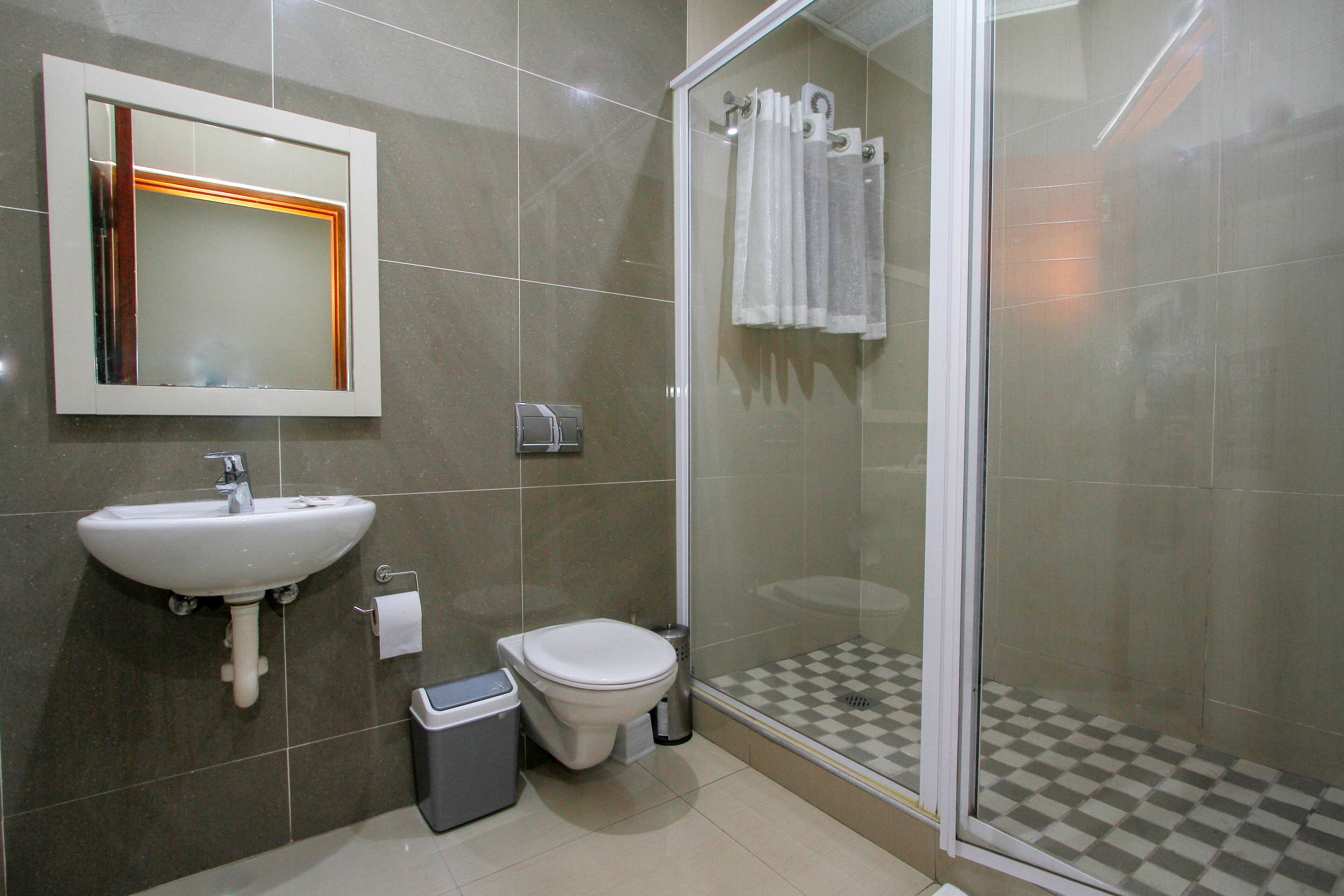 Un bagno con lavandino, WC e cabina doccia in vetro.