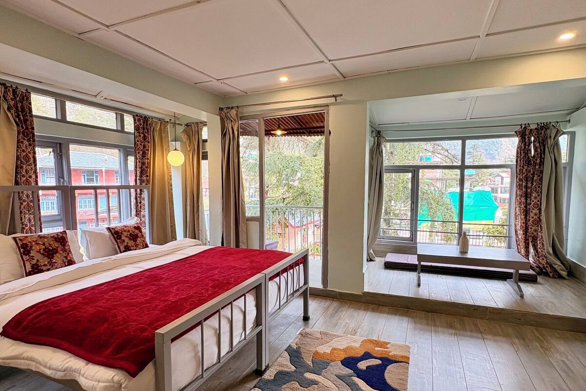 Ein Schlafzimmer mit Bett, einer Bank und Blick nach draußen.