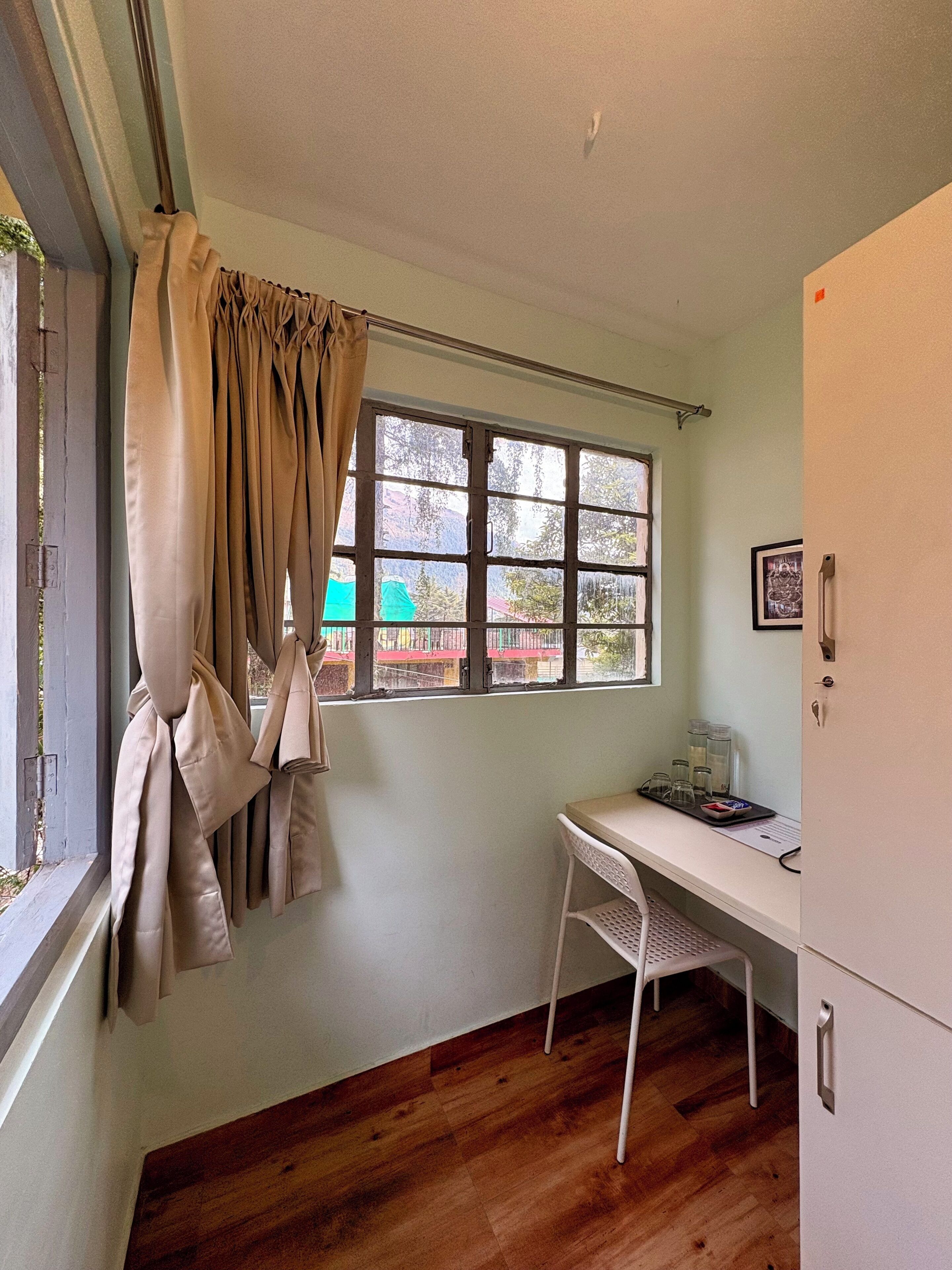 Una habitación con ventana, escritorio y silla.