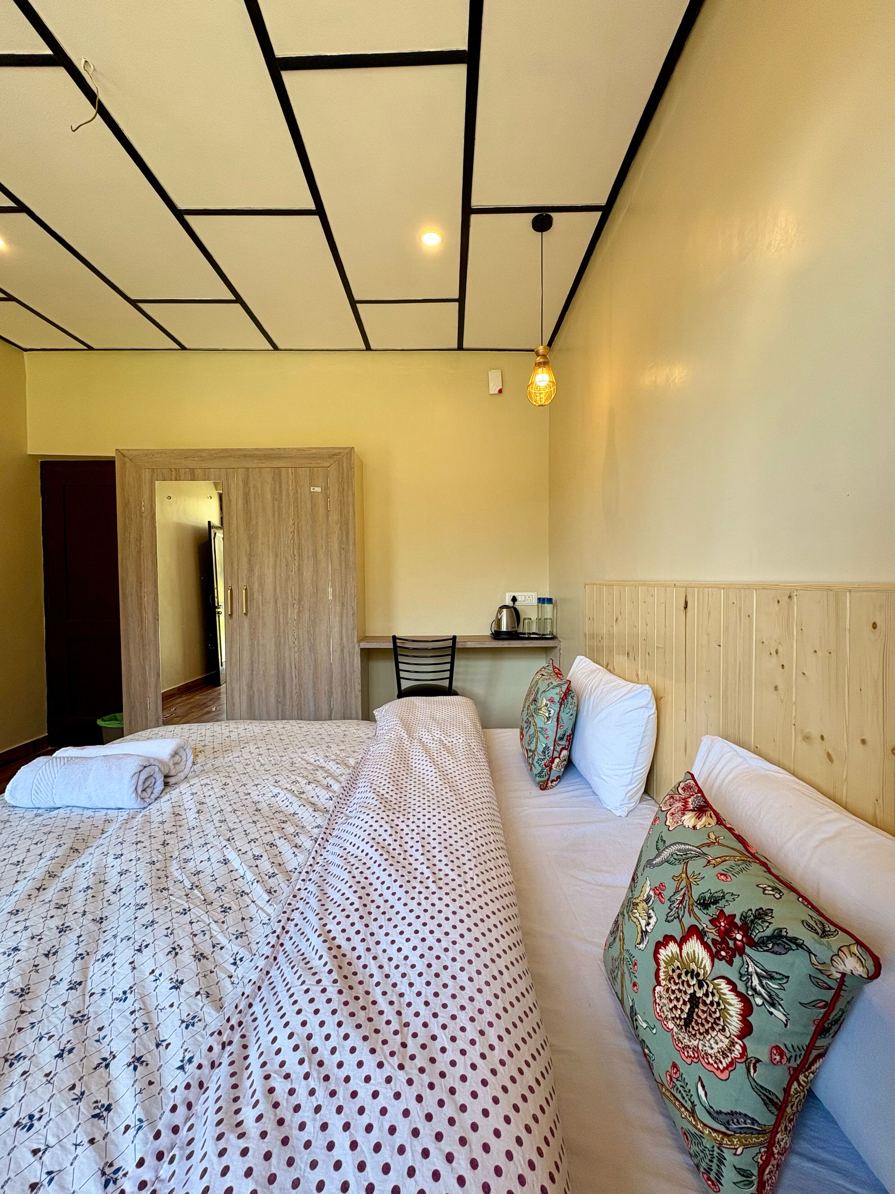 A hotel room with a bed, a desk, and a chair.