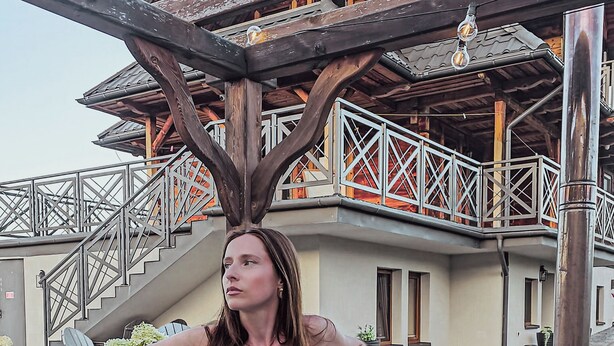 A person in a hot tub with a wooden structure and metal railings in the background. - Nasza Chata- hottub, fireplace, kids-friendly, grill, workspace, free parking (Kacwin)