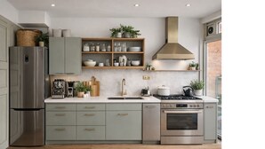 Una cocina moderna con refrigerador de acero inoxidable, horno empotrado y estufa a gas.