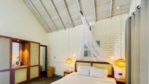 Un dormitorio con cama, dosel, pared de ladrillo y suelo de madera.