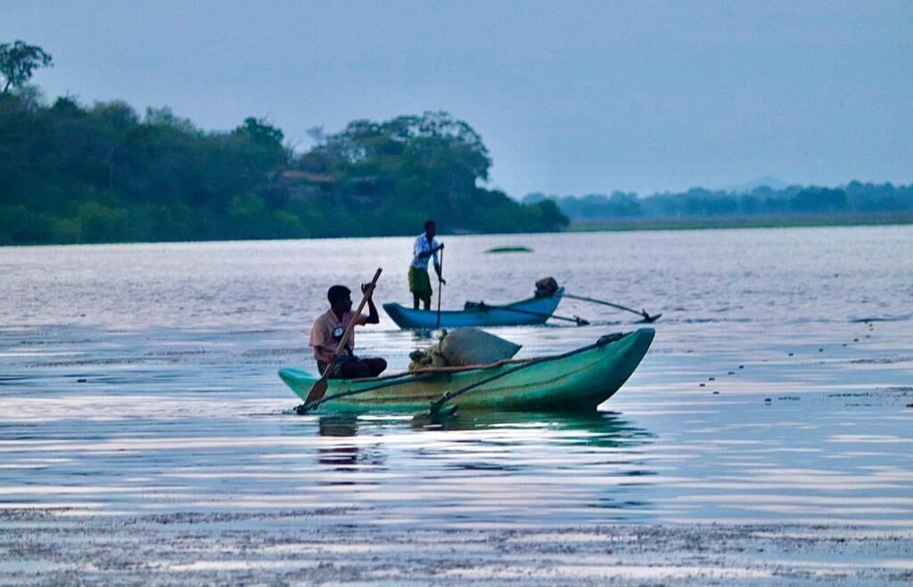 Una masa de agua tranquila con barcos y gente.