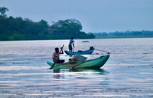 Una masa de agua tranquila con barcos y gente.